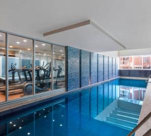 a swimming pool with blue water in a building at Coast on Colley Luxury 1BR Glenelg in Glenelg