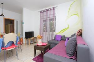 - un salon avec un canapé et une télévision dans l'établissement Apartments by the sea Kastel Kambelovac, Kastela - 20605, à Kaštela