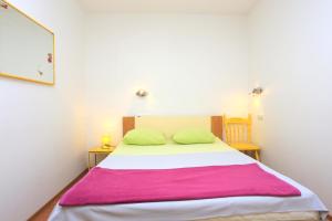- une chambre avec un lit et une couverture rose dans l'établissement Apartments by the sea Kastel Kambelovac, Kastela - 20605, à Kaštela