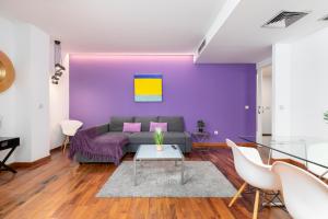 Sala de estar de color púrpura con sofá y mesa en Baron Suites, en Valencia