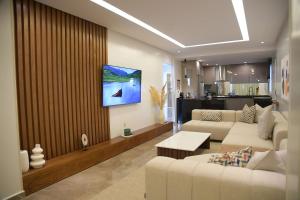 a living room with a couch and a tv on a wall at AKS Home appart 2 - CABONEGRO in Cabo Negro