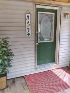 a green door on a house with a pink rug at Mi-o My Getaway in Mio