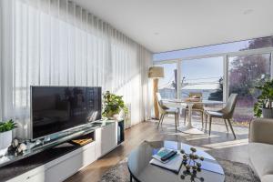 a living room with a large television and a table at Kirra Views in Gold Coast