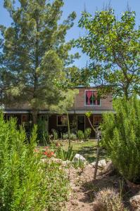 a house with a garden in front of it at Un lugar en el mundo in Mina Clavero