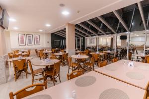 an empty dining room with tables and chairs at Hotel Caiuá Express in Maringá