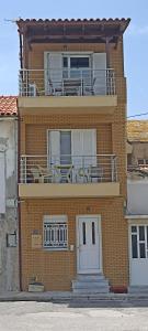 um edifício com uma varanda com mesas e cadeiras em Porta di Sabbia in Koum Kapi beach em Chania Town