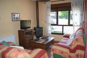 Una sala de estar con dos sofás y un televisor. en Casa Rural Arroal, en Sotoserrano