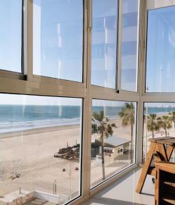 um quarto com janelas com vista para a praia em Quiero Cádiz em Cádis