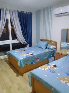 1 dormitorio con 2 camas y sábanas saludables en شاليه سياحي بمارينا دلتا لاجونز المنصورة الجديدة en Al Ḩammād