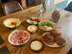 una mesa de madera cubierta con cuencos de diferentes tipos de comida en Casa Vida Alegre, en Prazeres