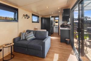 ein Wohnzimmer mit Couch und Küche in der Unterkunft Peace in Paradise - Tokerau Beach Holiday Home in Tokerau Beach