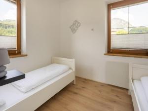 een witte kamer met een bed en 2 ramen bij Holiday home in the ski area in Kötschach-Mauthen in Laas