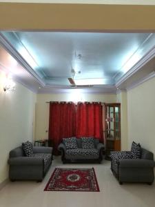 ein Wohnzimmer mit Sofas und einem roten Vorhang in der Unterkunft Spacious Penthouse in heart of city. By GEC circle in Chittagong