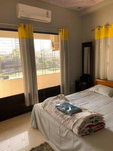 a bedroom with a bed and a large window at Spacious Penthouse in heart of city. By GEC circle in Chittagong