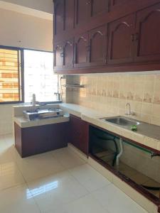 a kitchen with wooden cabinets and a sink at Spacious Penthouse in heart of city. By GEC circle in Chittagong