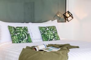 a bed with a book on it with pillows at Villa Coco in Lamai