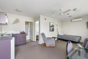 uma cozinha e uma sala de estar com um sofá em BK's Chardonnay Motor Lodge em Masterton