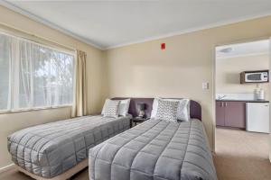 um quarto com 2 camas e uma janela em BK's Chardonnay Motor Lodge em Masterton