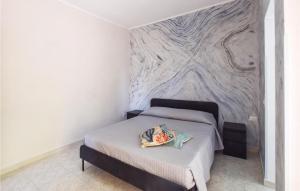 1 dormitorio con cama y pared de mármol en 2 Bedroom Lovely Apartment In Marina Di Strongoli, en Marina di Strongoli