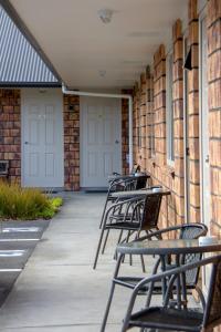 una fila di panche sedute sul lato di un edificio di BK's Chardonnay Motor Lodge a Masterton