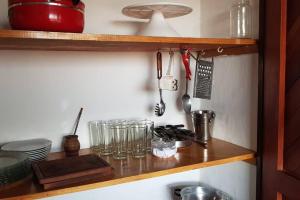 a kitchen shelf with glasses and utensils on it at Quinta El Descanso in General Alvarado