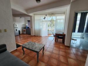 a living room with a table and a dining room at 1 BR APT with AC , TV , wi-fi near DT and beach in Zihuatanejo