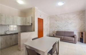 cocina con mesa blanca y sofá en 2 Bedroom Lovely Apartment In Marina Di Strongoli, en Marina di Strongoli