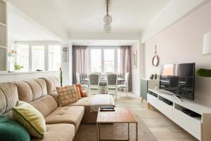 a living room with a couch and a tv at Quarto confortável com varanda in Amadora