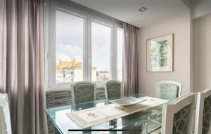 a dining room with a glass table and a window at Quarto confortável com varanda in Amadora