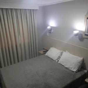 een slaapkamer met een bed met 2 kussens erop bij Paulista Flat in Sao Paulo