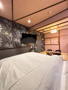 um quarto com uma cama e uma televisão na parede em ホテル水明 em Koriyama