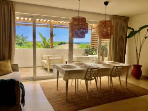 a living room with a table and chairs and a view of the ocean at Residencial Mañanero in Cabarete