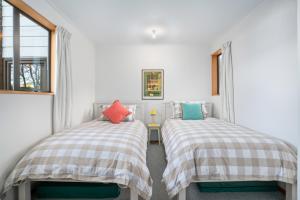 two twin beds in a room with a window at Wanaka Tranquility - Wanaka Holiday Home in Wanaka