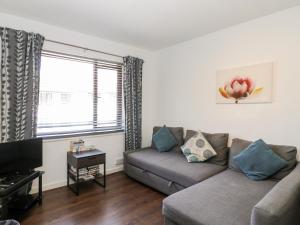 a living room with a couch and a tv at Sea Breeze in Burnham on Sea