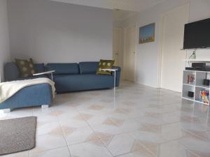 a living room with a blue couch and a tiled floor at Albany Sands in Cowes