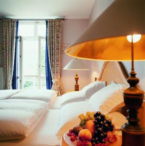 a room with two beds and a table with a bowl of fruit at Landhaus Zu den Rothen Forellen in Ilsenburg