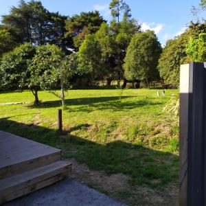 a park with a grassy field with trees and stairs at Akatarawa Valley Retreat a Cosy Two Bedroom Guest Suite in Upper Hutt