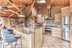 eine Küche mit Holzschränken und einer großen Insel in der Unterkunft Mesa Verde, Hot Tub, Pedestal Octagon Home / Mount in Ruidoso
