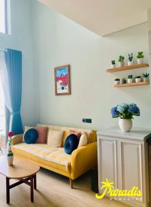 下龍灣的住宿－Citadines Marina Ha Long - Paradis Homestay，客厅配有带蓝色枕头的黄色沙发