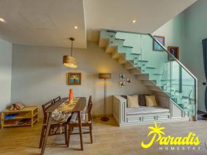 a living room with a staircase and a table and chairs at Paradis Homestay Marina Ha Long in Ha Long