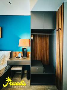 a bedroom with a bed and a desk with a lamp at Paradis Homestay Marina Ha Long in Ha Long