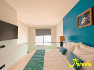 a bedroom with a bed with a blue wall at Paradis Homestay Marina Ha Long in Ha Long +30 photos