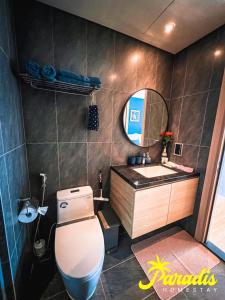 a bathroom with a toilet and a sink and a mirror at Paradis Homestay Marina Ha Long in Ha Long