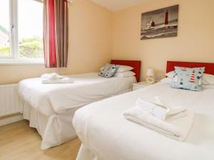 two twin beds in a room with a window at Pentewan in Hayle