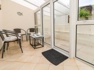a conservatory with glass doors and a table and chairs at Pentewan in Hayle
