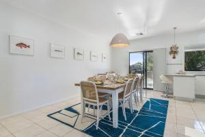 Un comedor blanco con una mesa y sillas. en Pacific Sounds, en Dunbogan