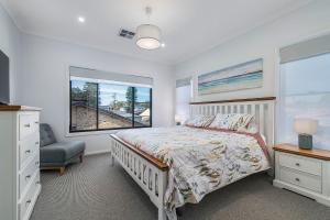 Un dormitorio blanco con una cama y una ventana. en Pacific Sounds, en Dunbogan
