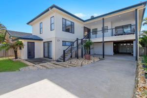 una gran casa blanca con entrada para coches en Pacific Sounds, en Dunbogan