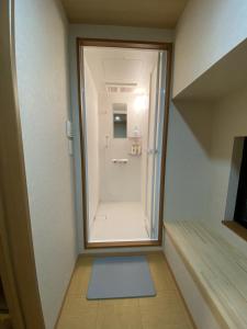 uma pequena casa de banho com uma cabina de duche ao nível do chão e um espelho. em WuTong梧桐 通天閣徒歩1分 NEW OPEN 景区内民宿 em Osaka