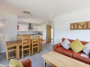 un soggiorno e una cucina con un divano rosso e un tavolo di Brunston Castle Lodge a Girvan